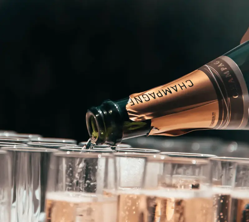 Close up on a champagne being poured into glasses