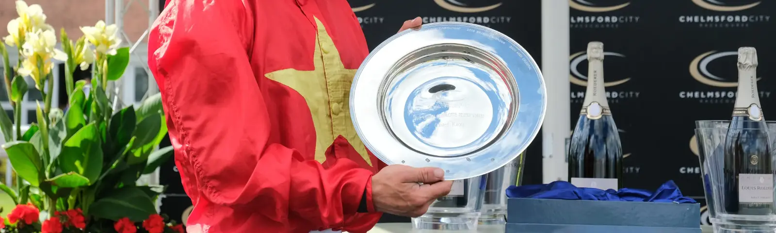 Jockey holding a trophy in hands.