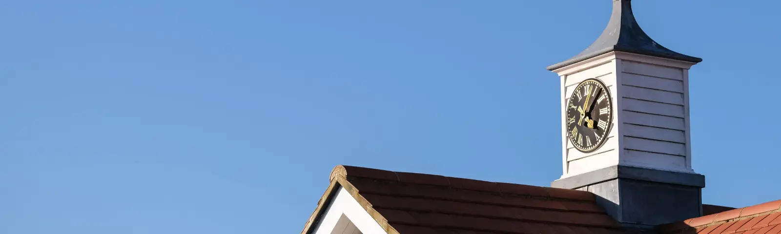 Clock on top of a building roof structure.